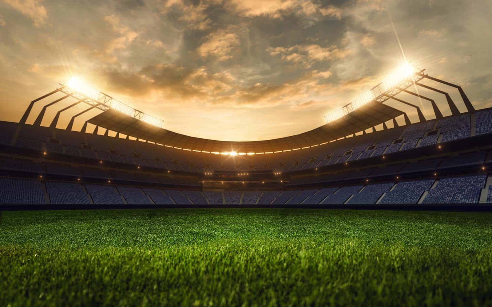 Stadium floodlights glowing over an empty field at dusk